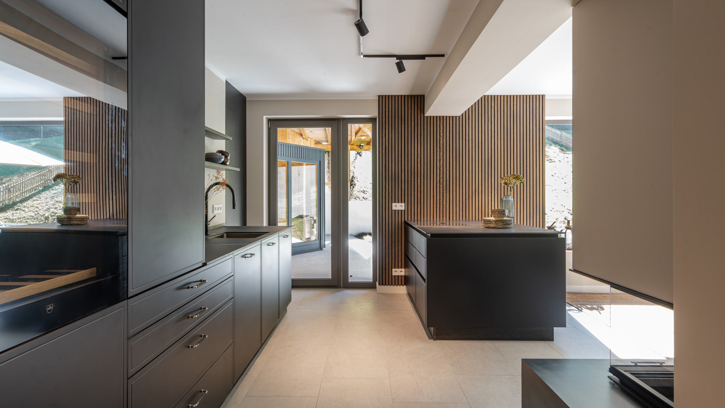 Elegante Küche mit schwarzen Fronten und halber Insel zum Wohnraum