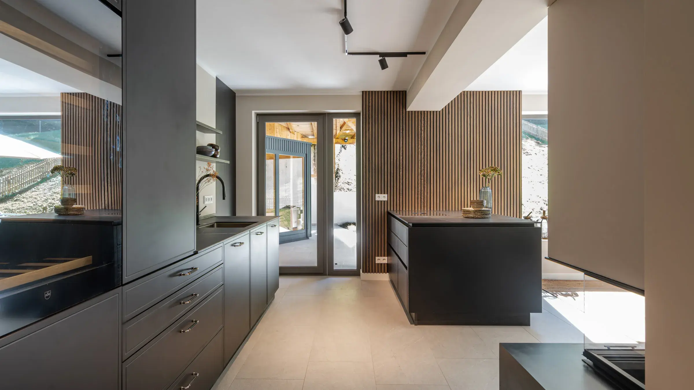 Elegante Küche mit schwarzen Fronten und halber Insel zum Wohnraum