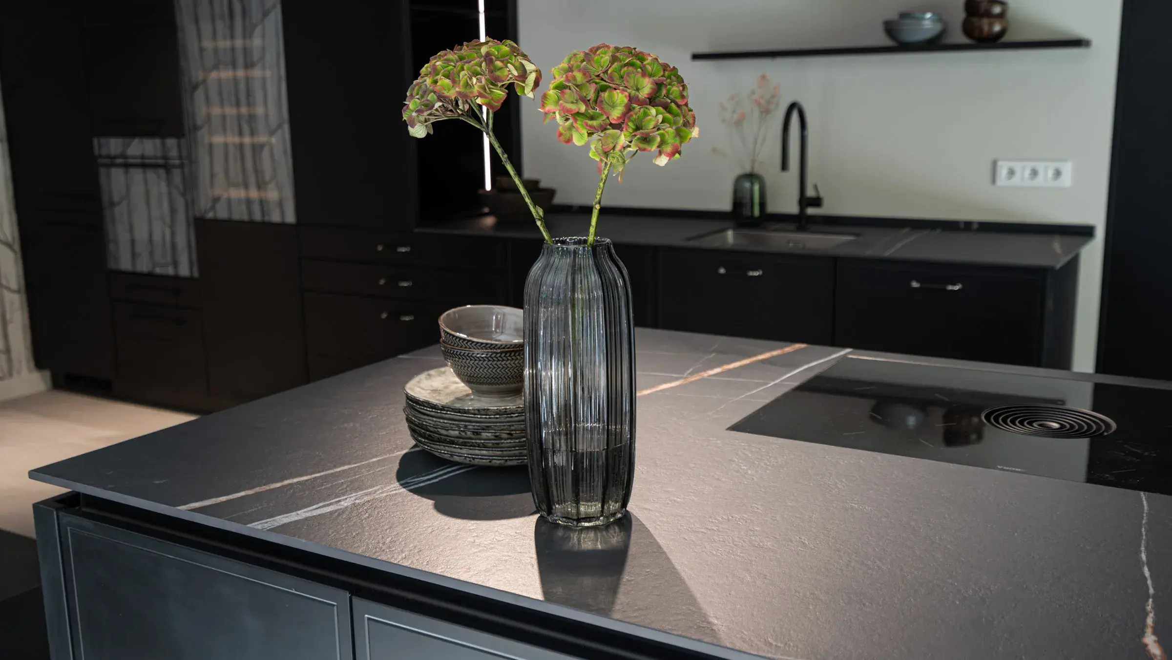 Kücheninsel mit schwarzer Keramikarbeitsplatte und Kochfeld